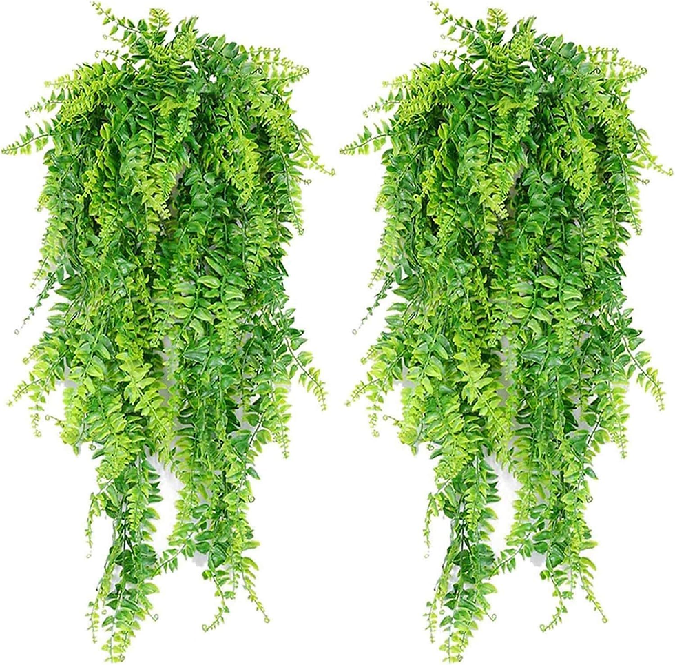 Duas samambaias artificiais pendentes, com folhagem densa em diferentes tons de verde, simulando um visual natural e volumoso. As plantas aparecem isoladas sobre fundo branco, destacando a textura detalhada das folhas.