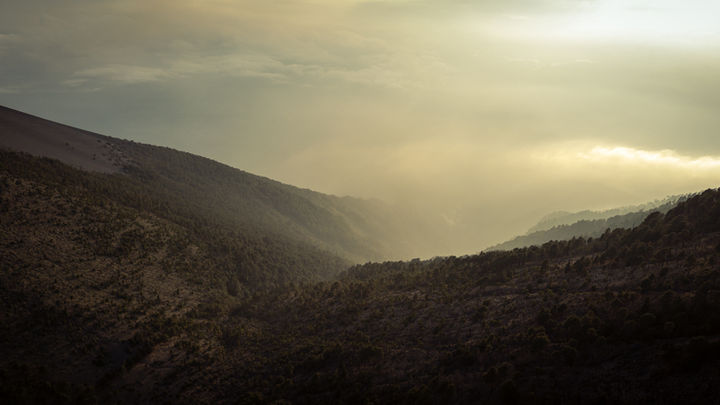 Besileidžianti saulė tarp kalnų