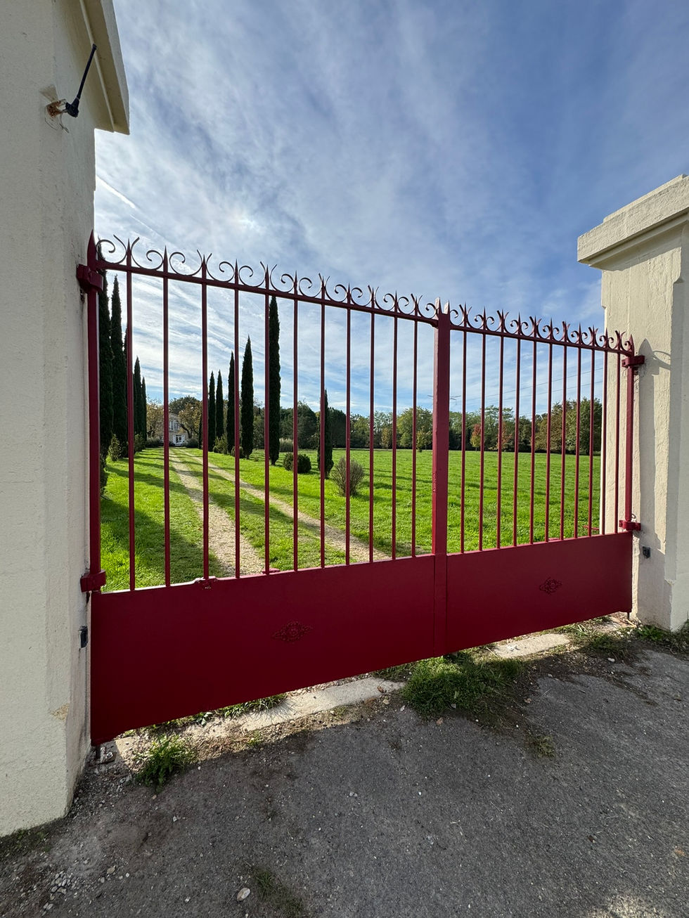 Portail en fer forgé noir installé à l’entrée d’un château