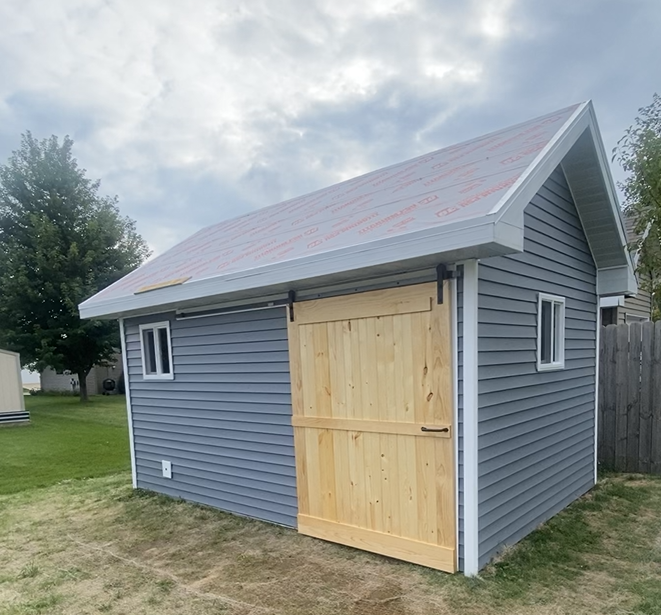 Custom shed with new vinyl siding and windows installed by JJ Exteriors