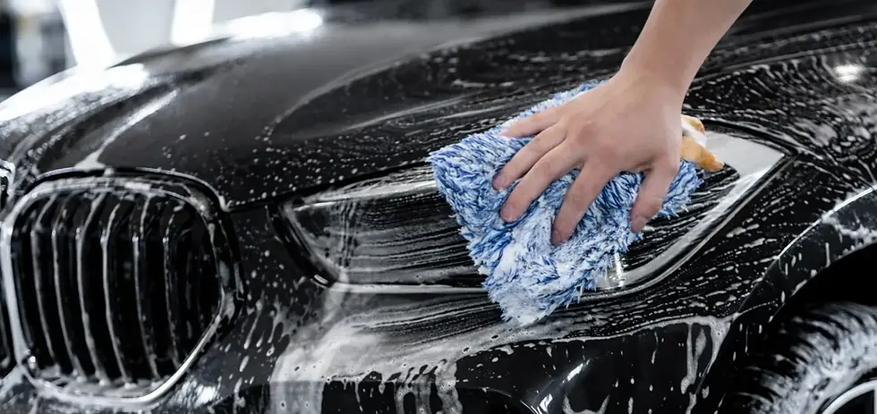 a close up of the team hand washing a black car