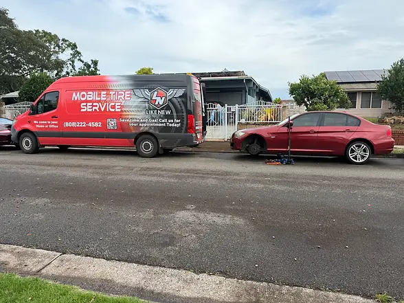 Mobile tire service van assisting a vehicle during a roadside tire service call.