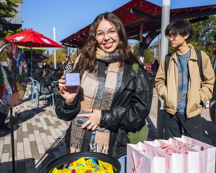 One of our attendees posing with the skincare product they won from our pop up.