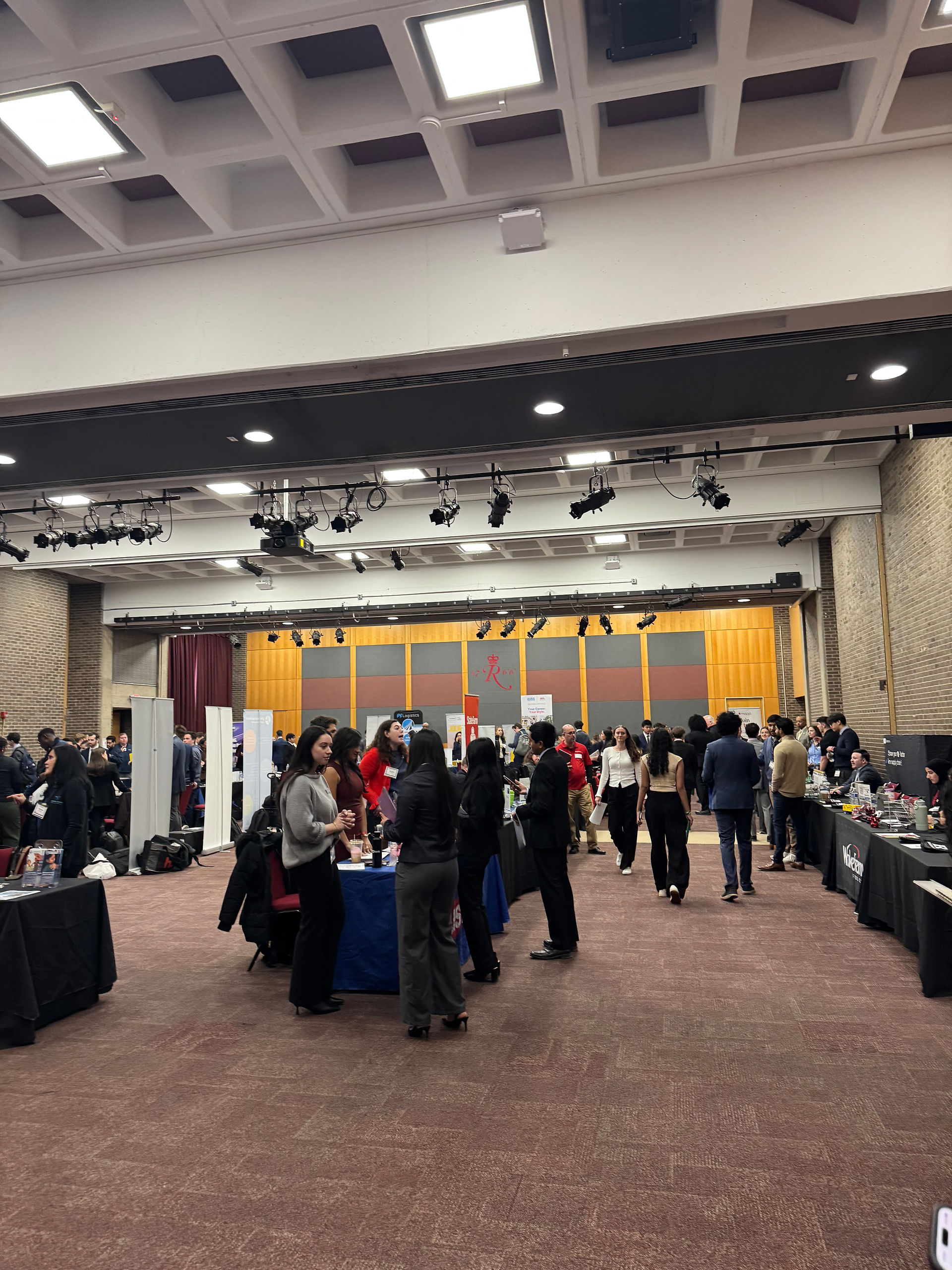 Advanced Creative Media employees conversing with students at the Rutgers Business School career fair.