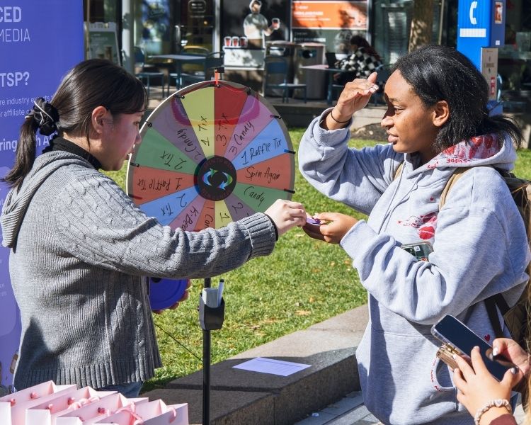 Our staff giving a ticket to a event attendee who won our spin the wheel game.