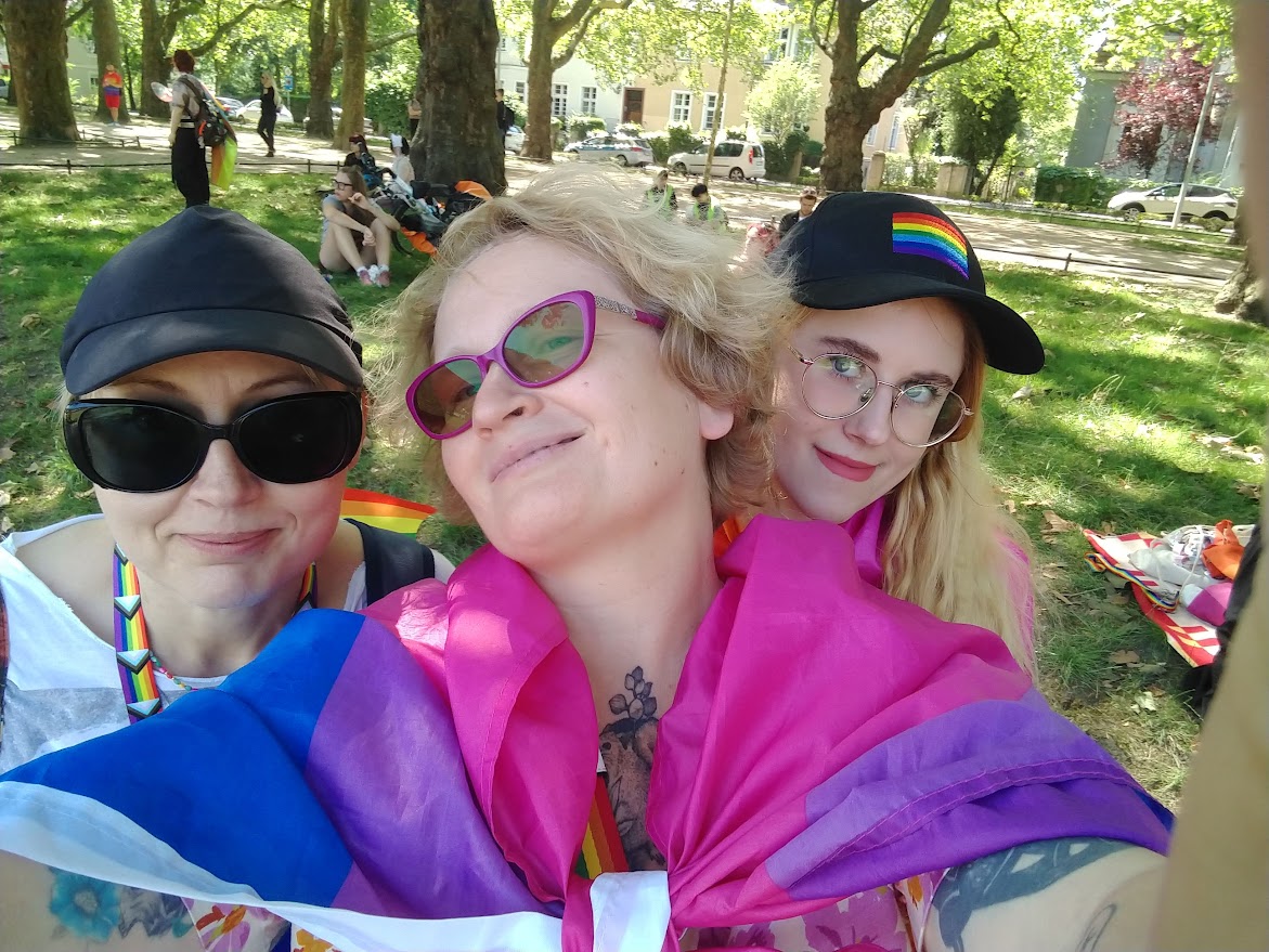 trzy osoby stoją blisko siebie i uśmiechają się do zdjęcia