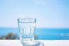 glass-beaker-filled-with-clear-water-stands-sandy-beach-by-sea-healthy-lifestyle_73975-72.