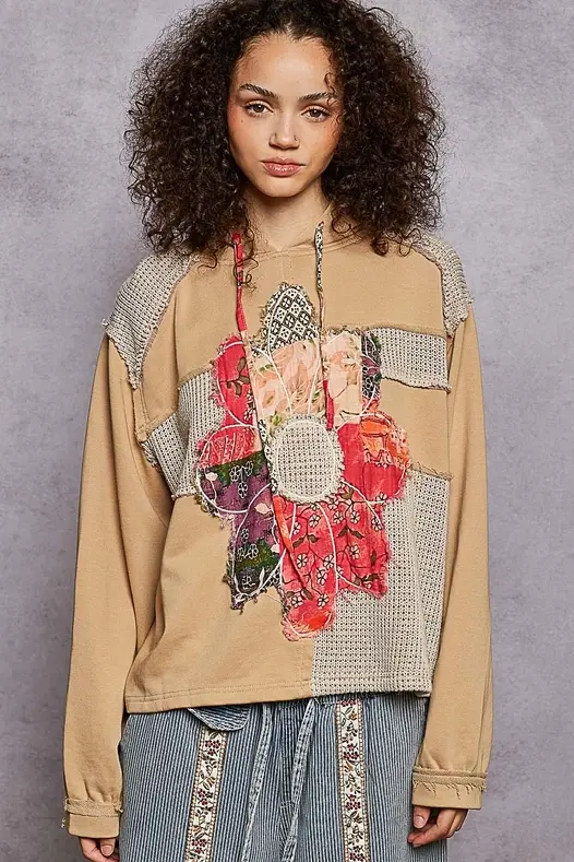 Model with brown curly hair wearing a Long Sleeve French Terry Printed Flower Patch Knit Top, front view.