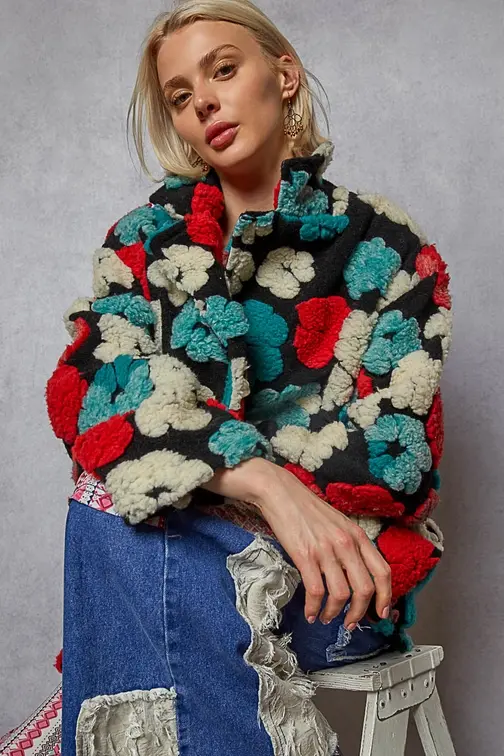 Thumbnail: Front of long-sleeve textured sherpa floral coat with red, teal, white, and black, worn closed with jeans.