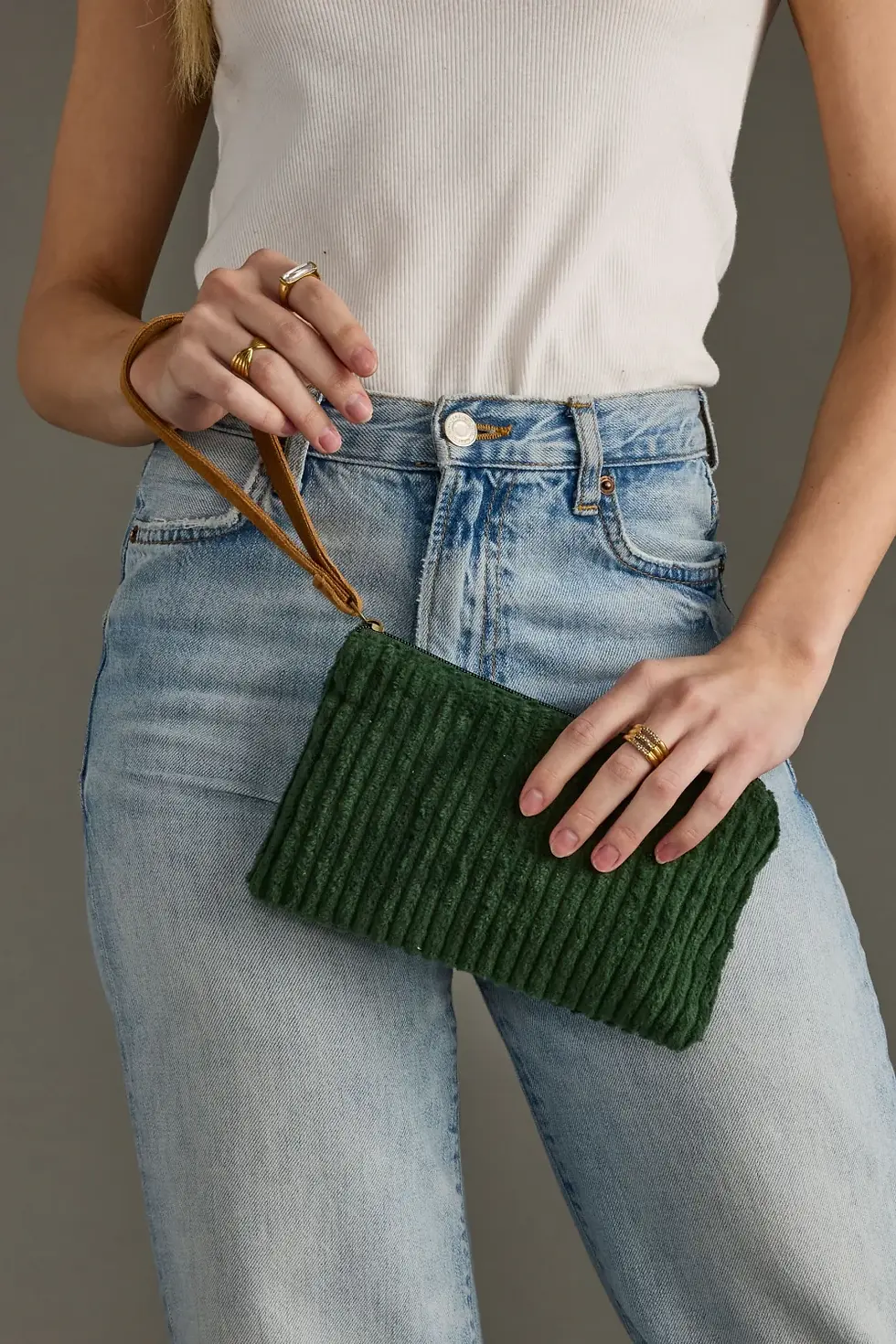 Dark Green Corduroy Wristlet being held by the leather strap and worn with a casual outfit.