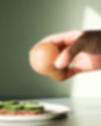 rundund Gewürzstreuer aus Holz in der Anwendung – Salz wird über ein belegtes Brot mit Gurke gestreut.