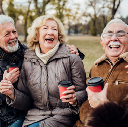 Personas de mayor edad riéndose mientras toman un café