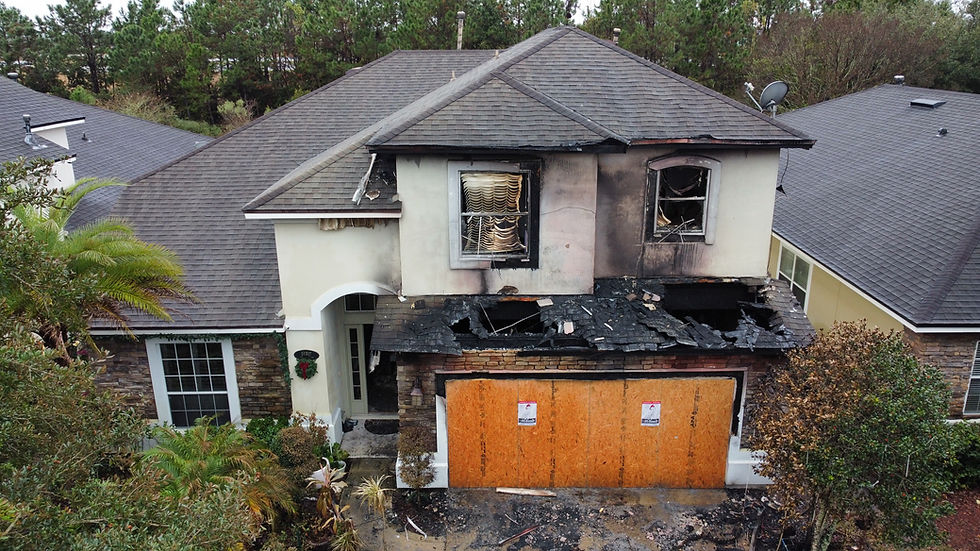 Two-story house with fire and smoke damage.