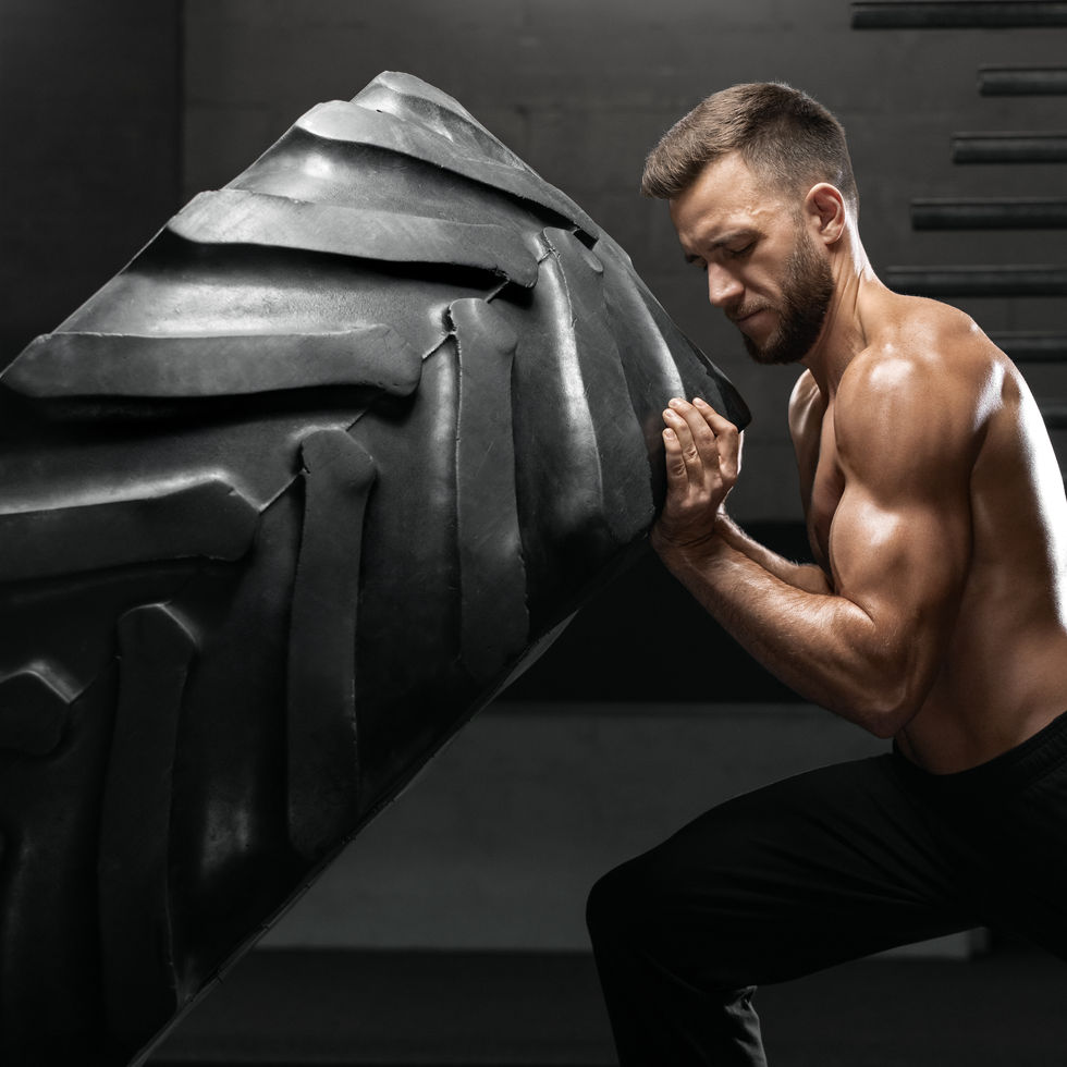 Buff guy working out by flipping a tire. TRT treatments in Texas can help you. 
