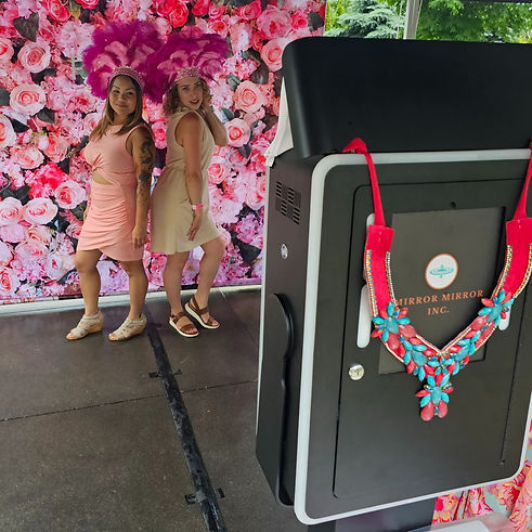 2 women posing in front a photo booth