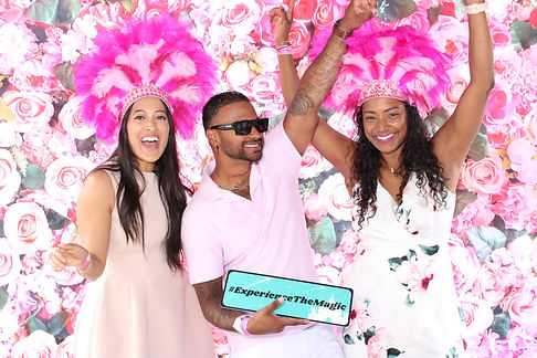 3 people posing with arms up. one holding a sign with the words "Experience the magic"