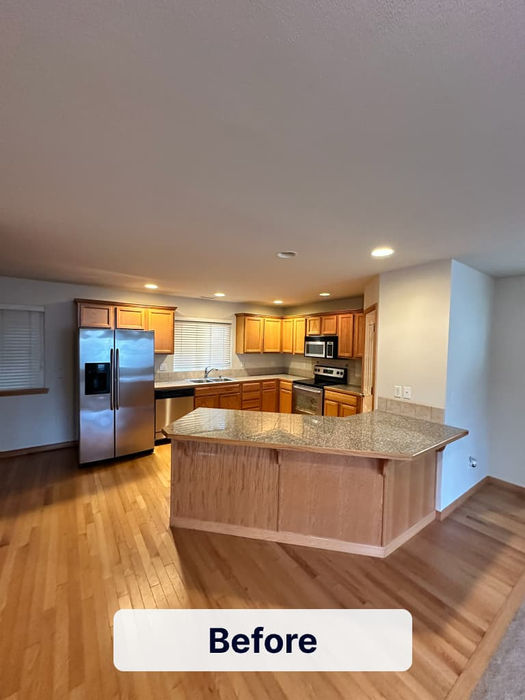 Modern kitchen remodel with wood cabinets, granite island countertop, stainless steel appliances, and hardwood flooring