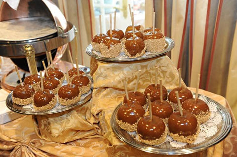 Caramel apples displayed on tiered platters at a wedding reception
