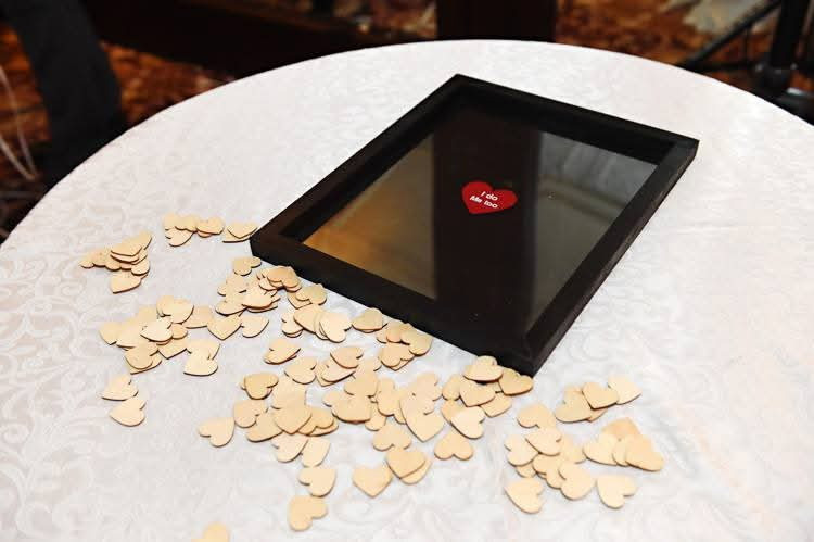 Black frame with red heart, surrounded by small wooden hearts