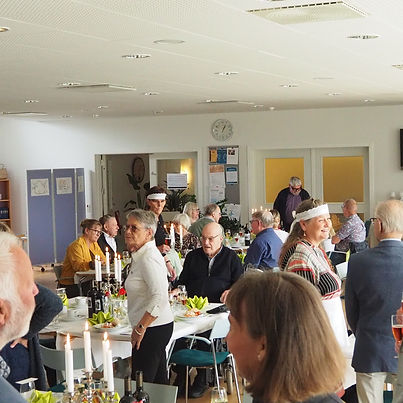 Voksne samlet til et socialt arrangement, flere med hvide pandebånd.