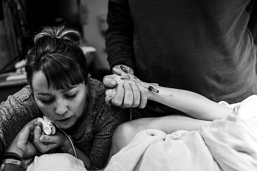 Doula and Husband holding laboring woman's hands while she is pushing at hospital in Sacramento Birth Photography