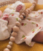 Ivory spikkel wagenspanner en houten bloemenring samen met een baby.