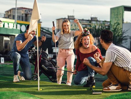 A group of adults playing mini golf.