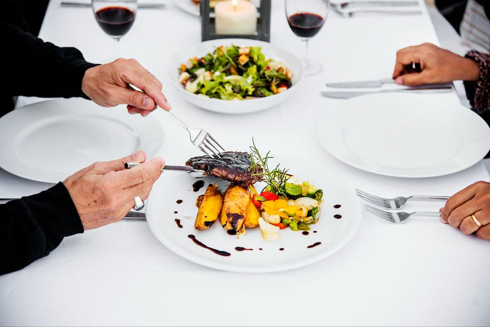 A close-up of seniors' hands getting dishes at a fine dining restaurant.