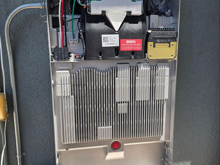Close-up of a solar battery system panel showing wiring, inverter connections, and energy storage components