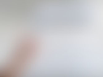 Person holding a remote next to an air conditioning unit on the wall. 