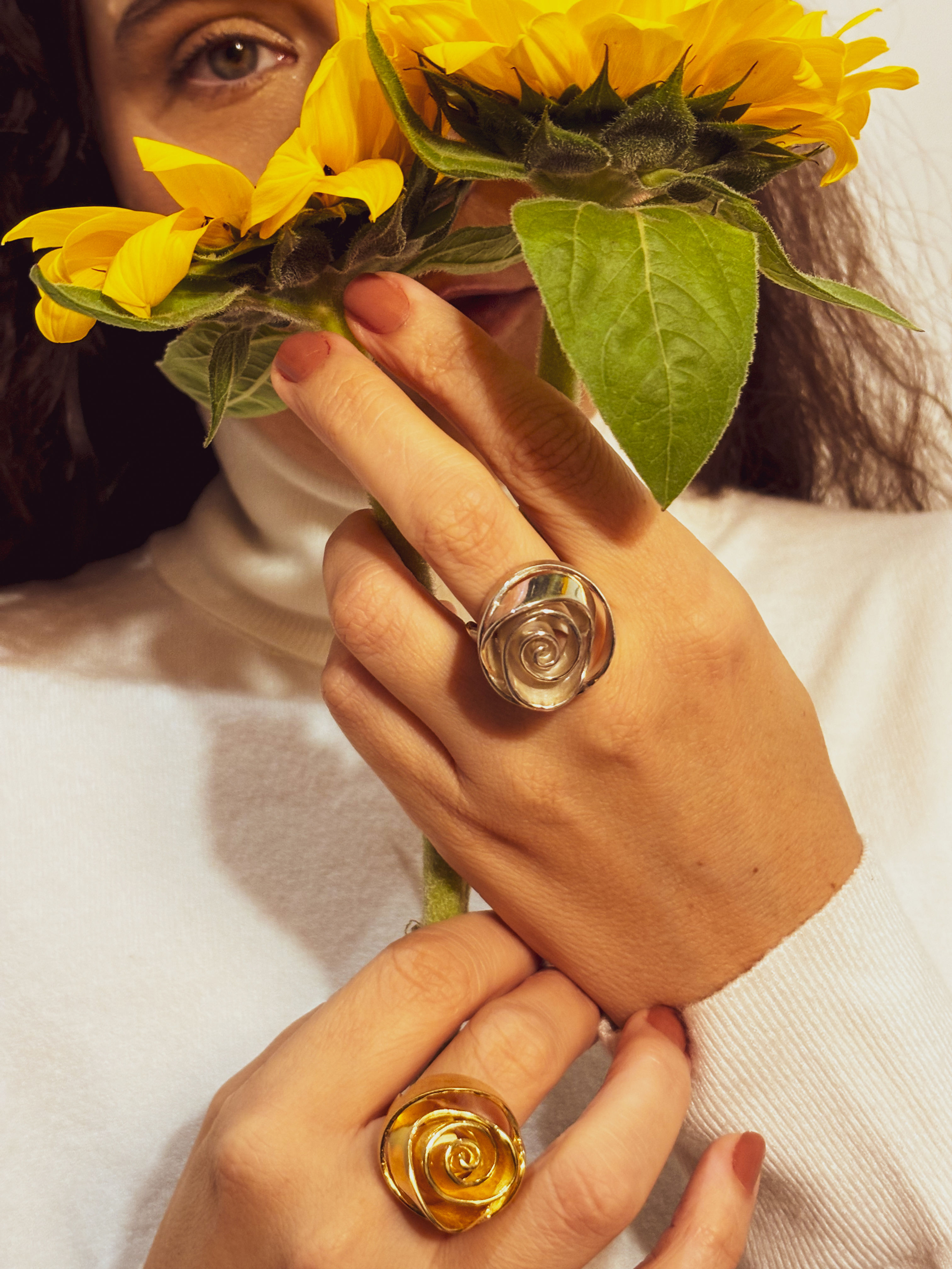 Detalhe das mãos erguidas da modelo, Anel Rosa em prata no dedo médio esquerdo e Anel Rosa em ouro no dedo médio direito