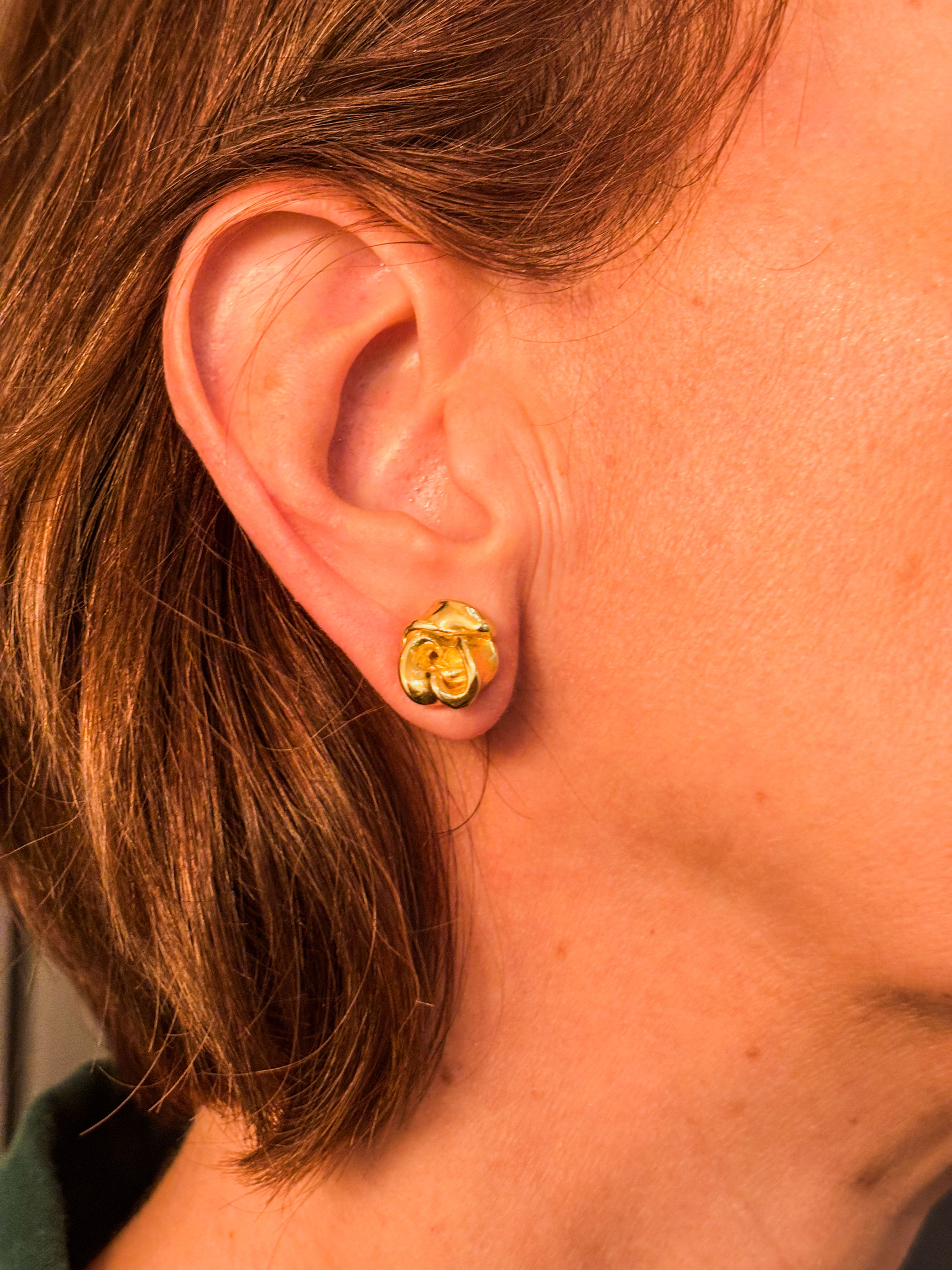 Brinco Rosa em ouro usado por modelo com cabelos curtos