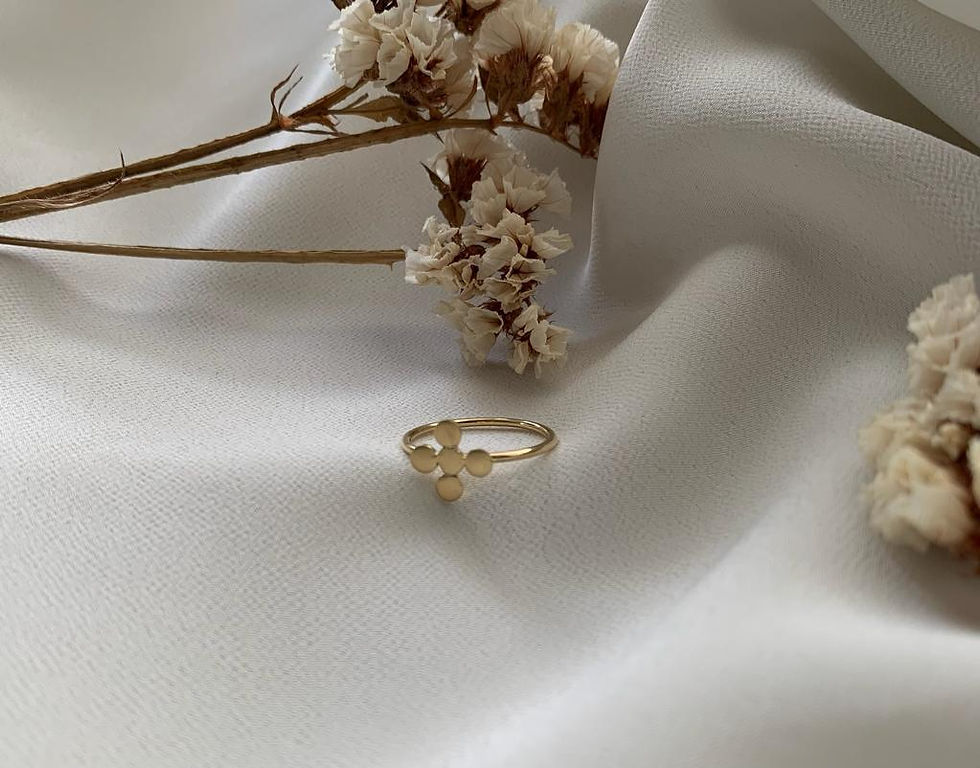 Aliança Apoio em ouro 18k ao lado de ramo de flores brancas sobre tecido diáfano branco