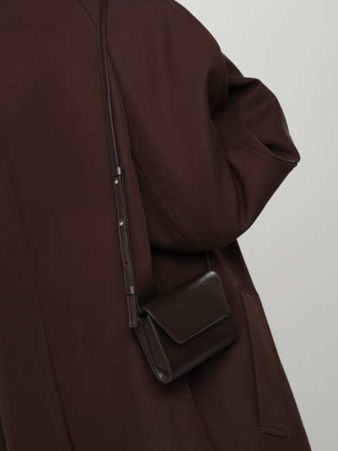 PALOMA leather cross body bag and clutch in chocolate brown on model for size and scale