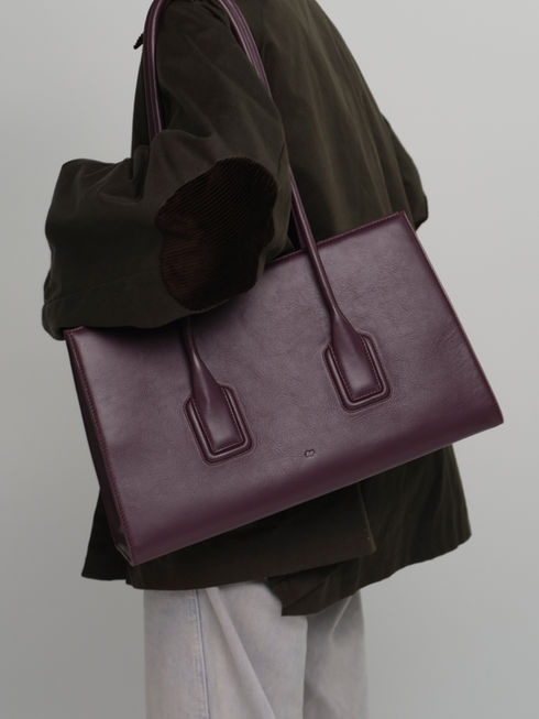 Model wearing the MATEO handcrafted leather tote bag in fig.