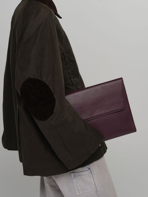 CLEO maxi envelope leather clutch in rich fig leather on model to show scale and size