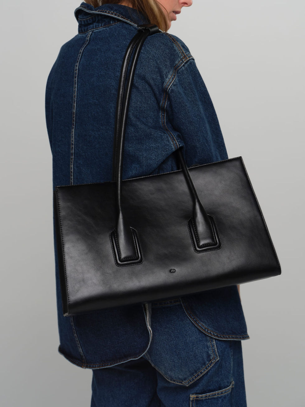Model wearing the MATEO handcrafted leather tote bag in black.