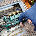 A boat service mechanic fixing the engine of a boat