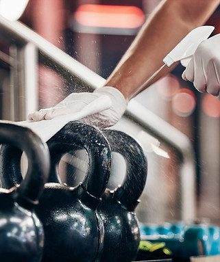 Kettlebell cleaning service hands cleaning gym with liquid soap spray bottle with cloth