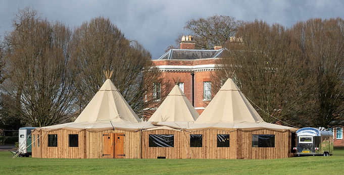 Three Tipi linked together with wooden sides to increase the space