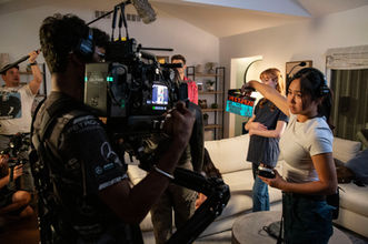 Film crew and cast on set during a behind the scenes shoot.
