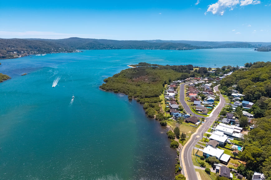 Aerial view of a coastal town by a blue bay with boats