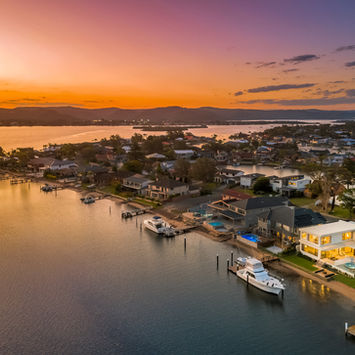 Aerial view of coastal town at sunset with boats