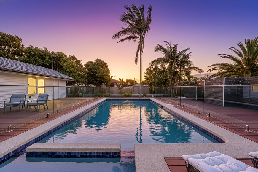 Swimming pool at sunset with palm trees