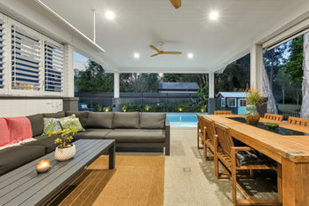 Covered patio with outdoor lounge, dining table, and pool
