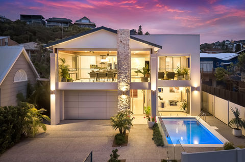 Contemporary home with pool and sunset sky