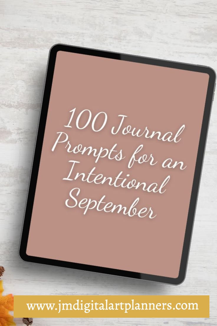 Tablet on light wood background displaying 100 Journal Prompts for an Intentional September, with www.jmdigitalartplanners.com below