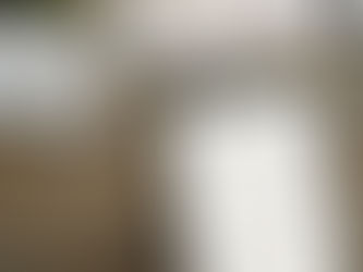 Tablet with a habit tracker on a rustic wooden desk. Nearby are a laptop, glasses, notebook, pen, and small plant. Calm and organized setting.