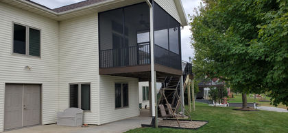 Ground view Trex Transcend Spiced Rum composite deck with black Westbury Screen Rail in a screened porch