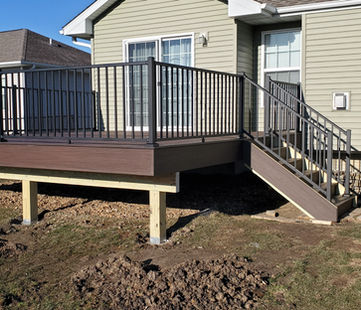 Raised backyard deck with black aluminum railings.”